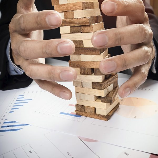 Planning risk strategy business concept businessman gambling placing wooden block tower 600x600