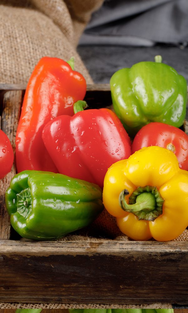 Color bell peppers rustic tray with water drops them 600x1000