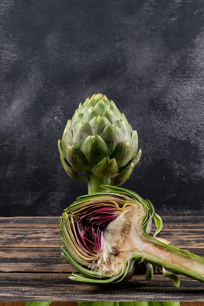 Side view artichoke slice dark wooden black background horizontal space text 683x1024